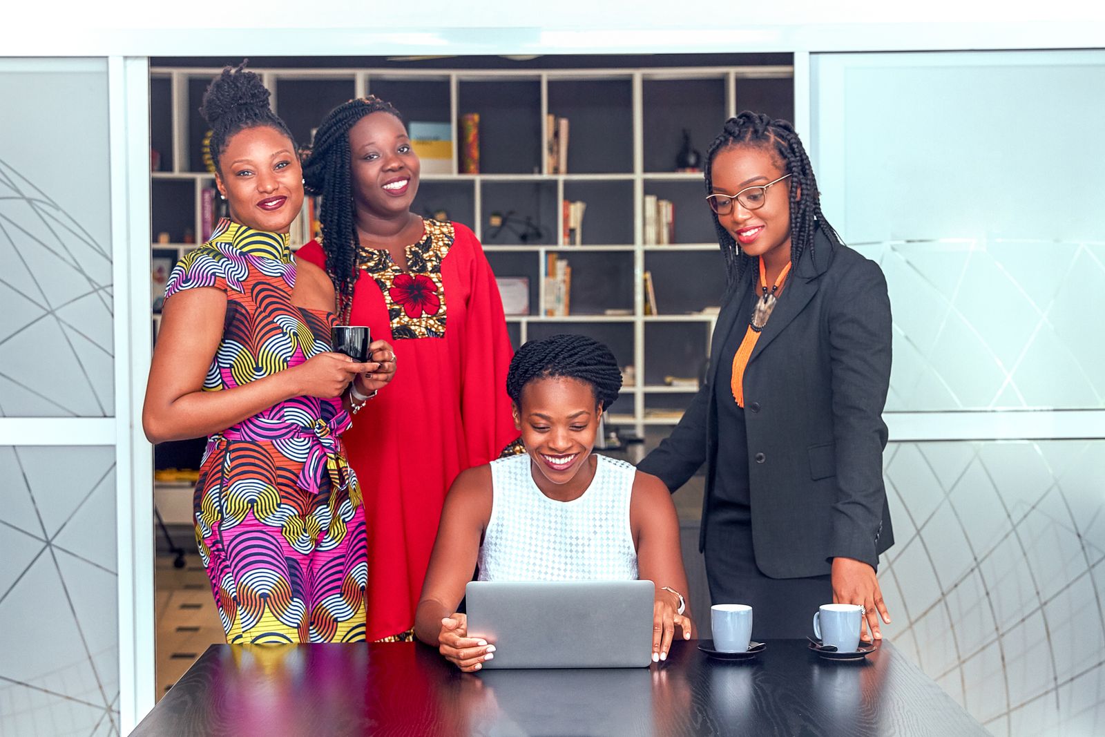 African professionals collaborating on a laptop in a modern office