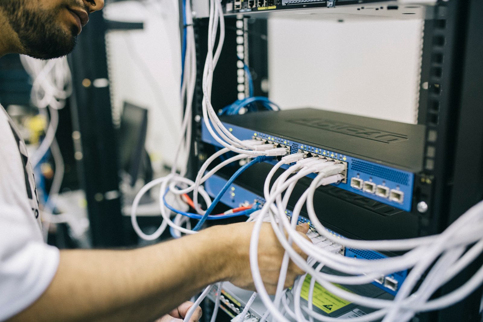 ICT technician configuring network cabling in a server rack